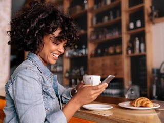 person smiling and drinking coffee