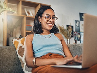 Woman smiling while working on laptop at home