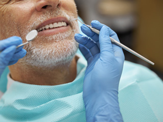 Man with gray facial hair about to undergo dental exam