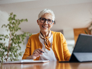 Woman with white hair in office working on tablet