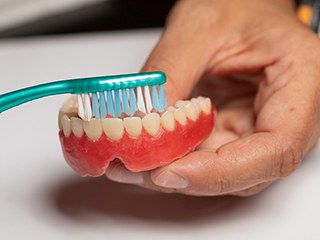 Man brushing dentures