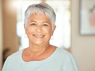 Senior woman with light blue shirt smiling