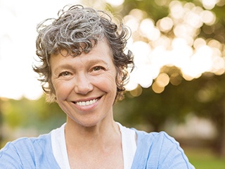 woman smiling after getting dental implants in McComb