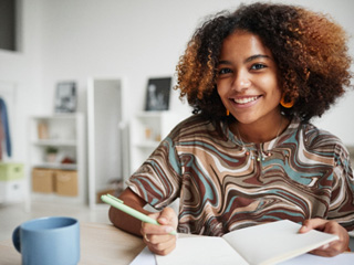 Teen girl smiling while working on homework