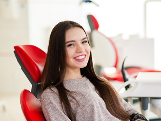Teen girl smiling while sitting in treatment chair