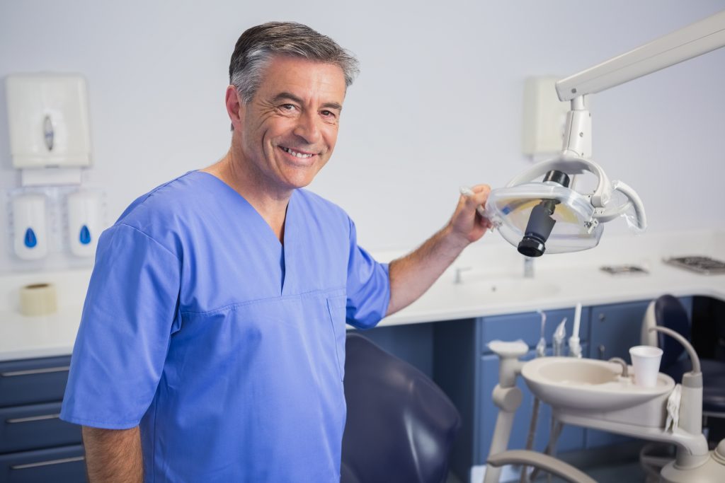 Smiling dentist with light