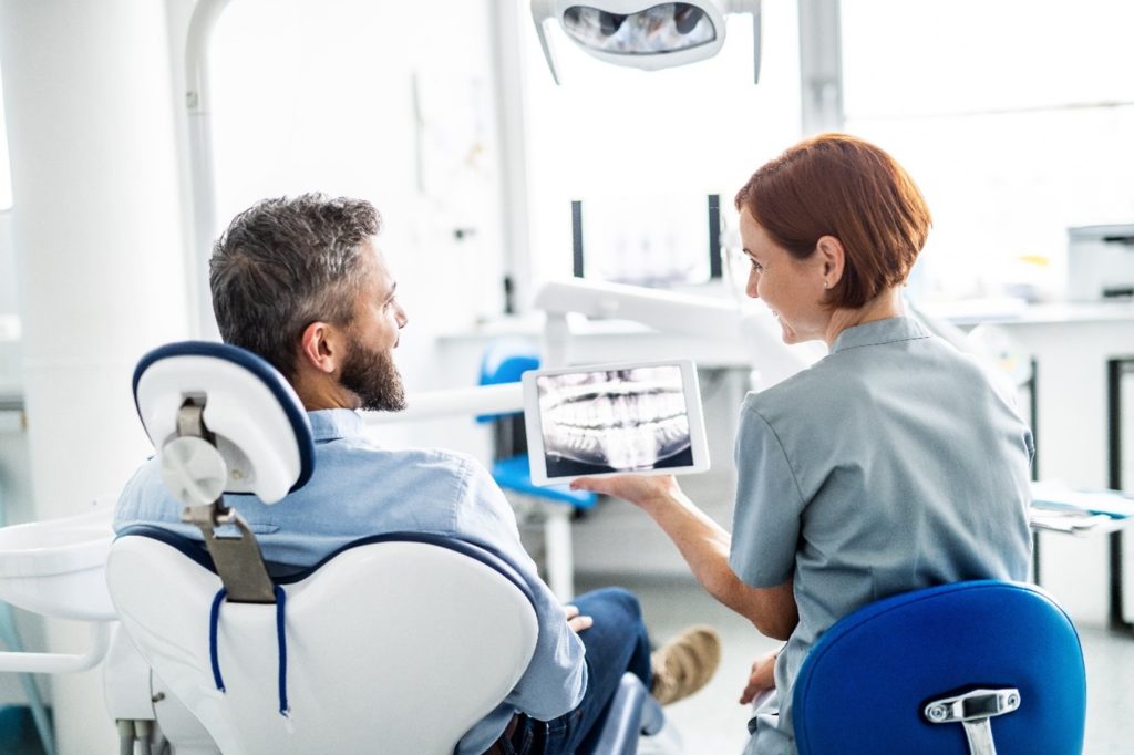 Dentist showing patient X-ray