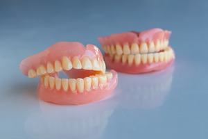 Close-up of full dentures on reflective table