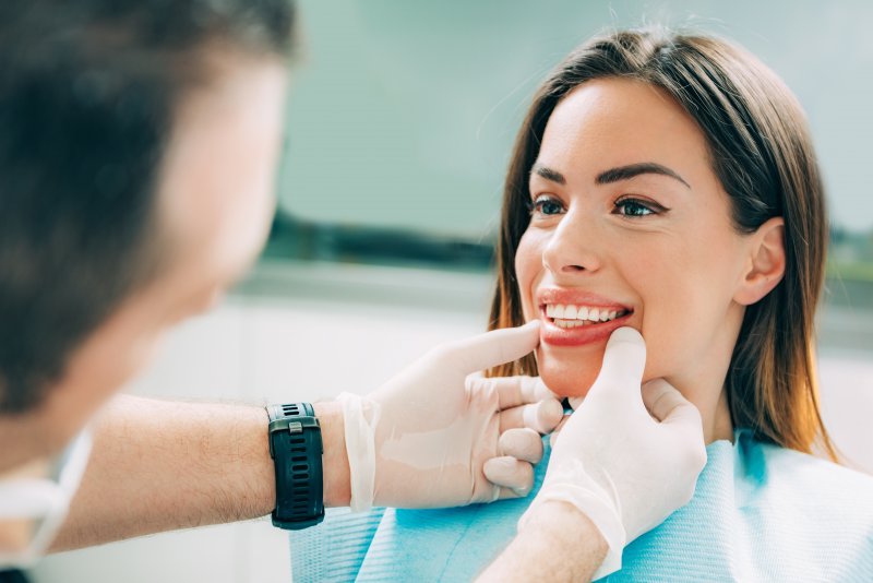 A dentist examining a woman for cosmetic dentistry