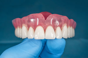 a dentist holding dentures