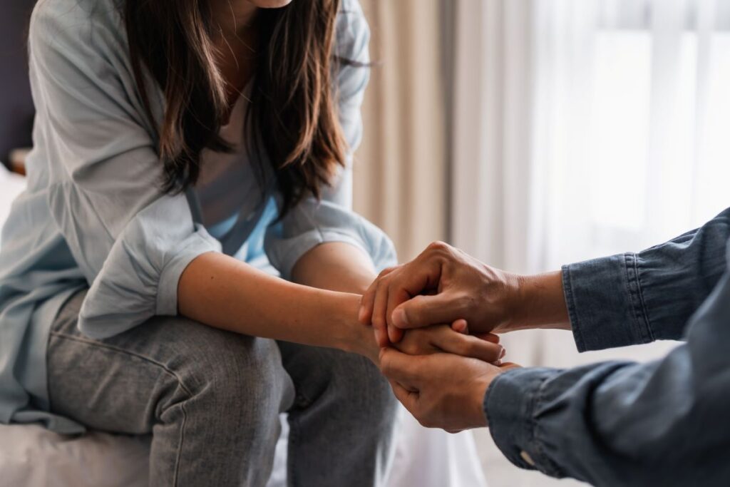 A man holding a woman’s hands.